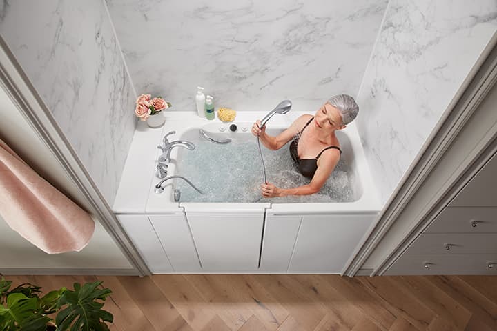 An elderly woman using a walk-in bathtub